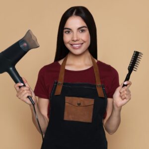 hair dresser holding a blow dryer and hair brush