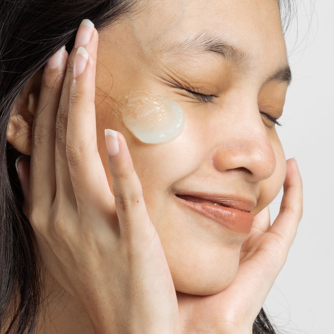 happy woman applying skin care products