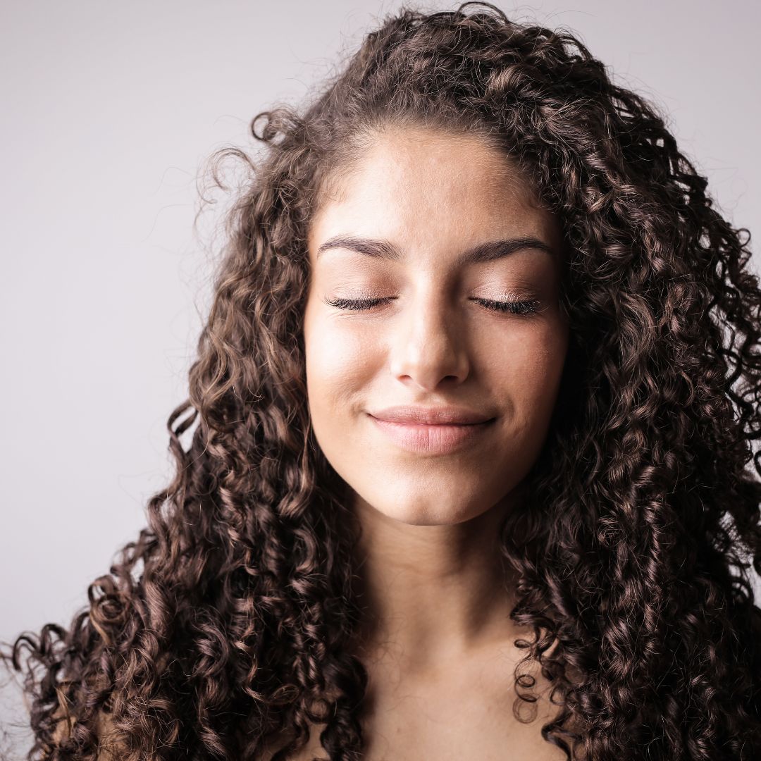 woman with curly hari smiling