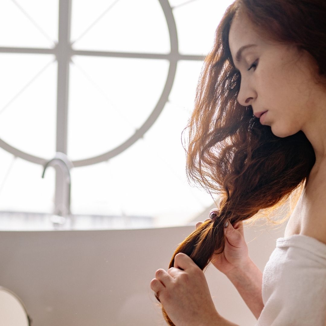 woman looking at her hair