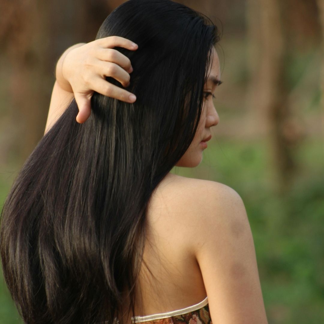 woman brushing her hands through her hair