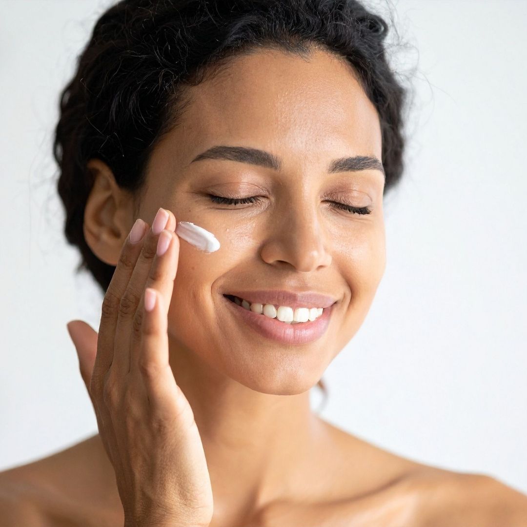 smiling woman applying facial moisturizer